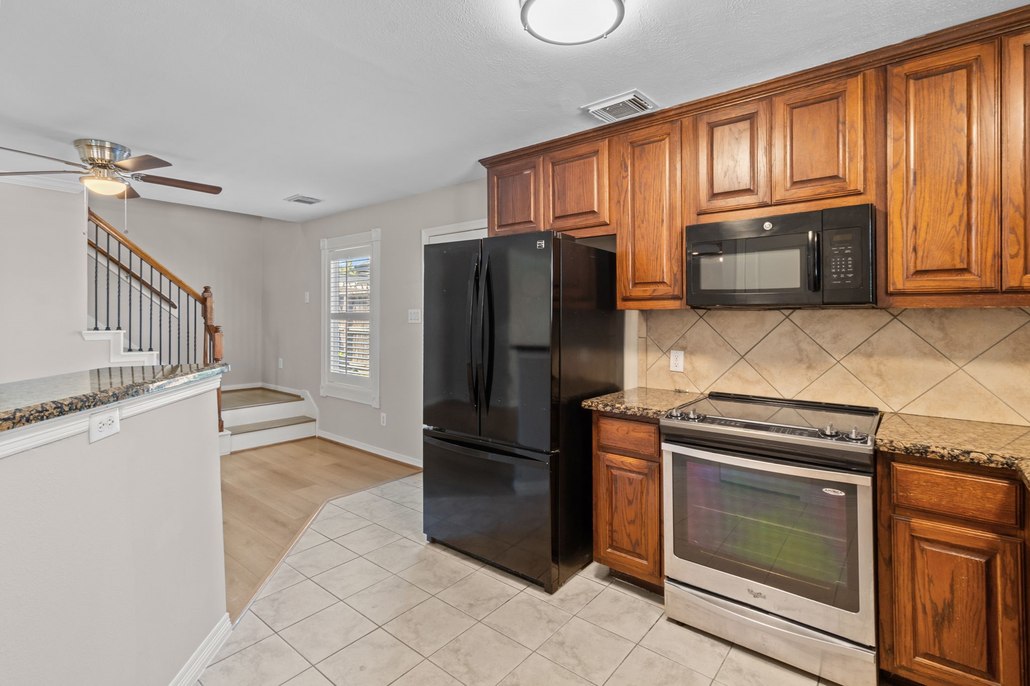 3506 Garrow Street Houston, TX 77003 - Photo 6 of 32 a kitchen with granite countertop a refrigerator stove and microwave
