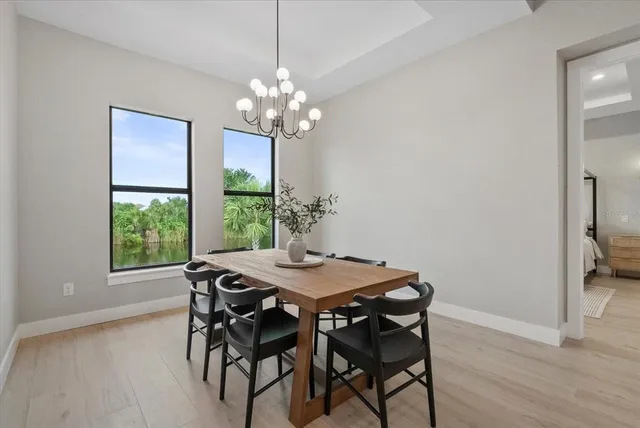 a kitchen with stainless steel appliances a sink a stove a table and chairs