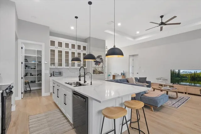 a kitchen with stainless steel appliances granite countertop a sink a stove and a refrigerator