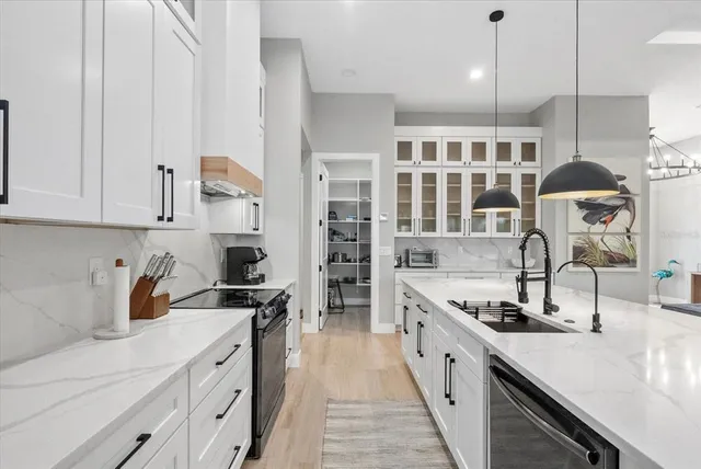 a kitchen with stainless steel appliances white cabinets and a window