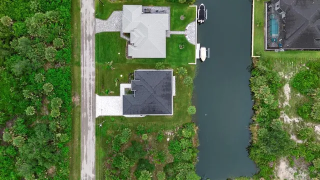 an aerial view of residential houses with outdoor space and trees