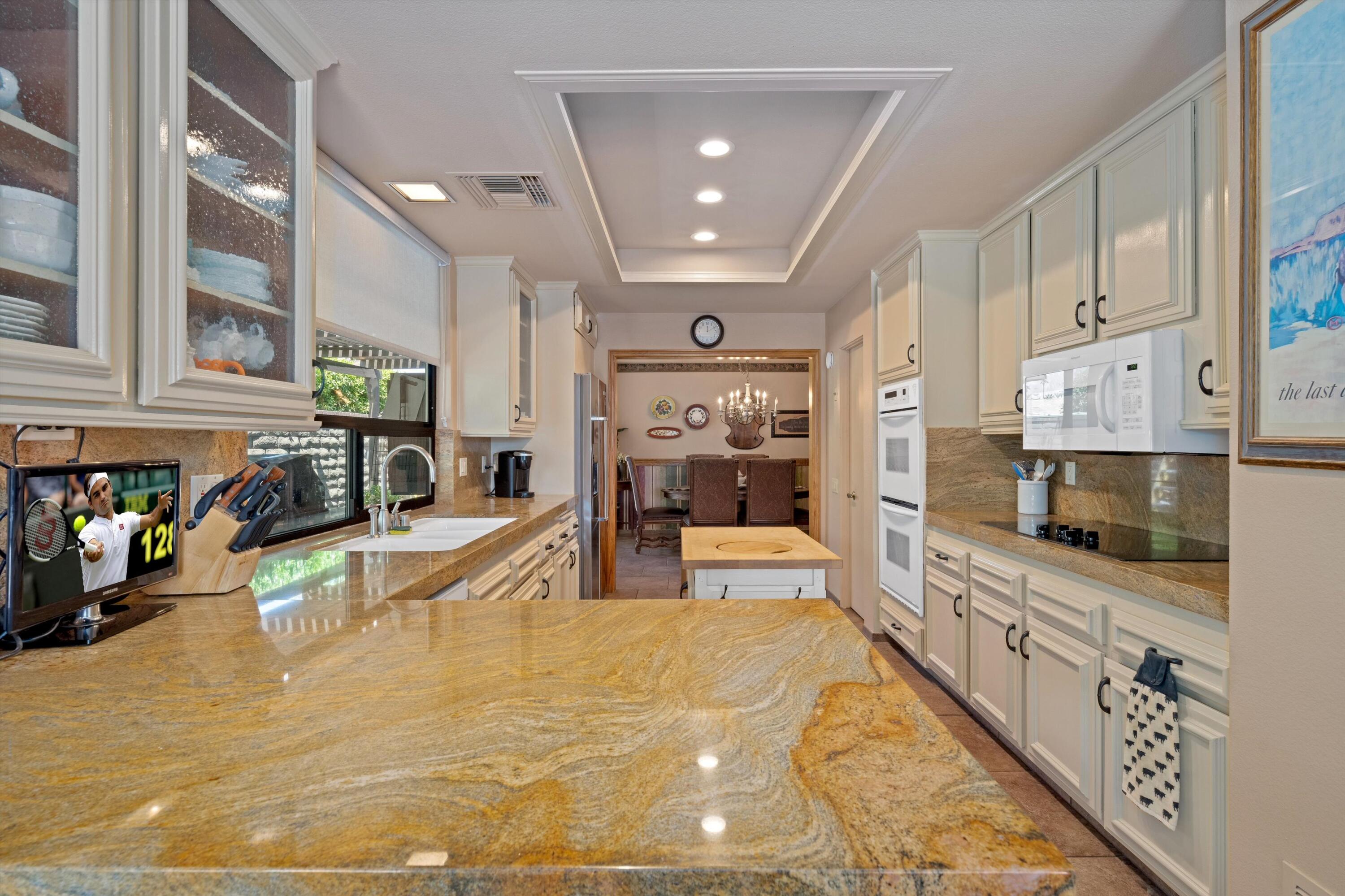 48 Cornell Drive Rancho Mirage, CA 92270 - Photo 13 of 39 a large kitchen with stainless steel appliances lots of counter space and wooden floor