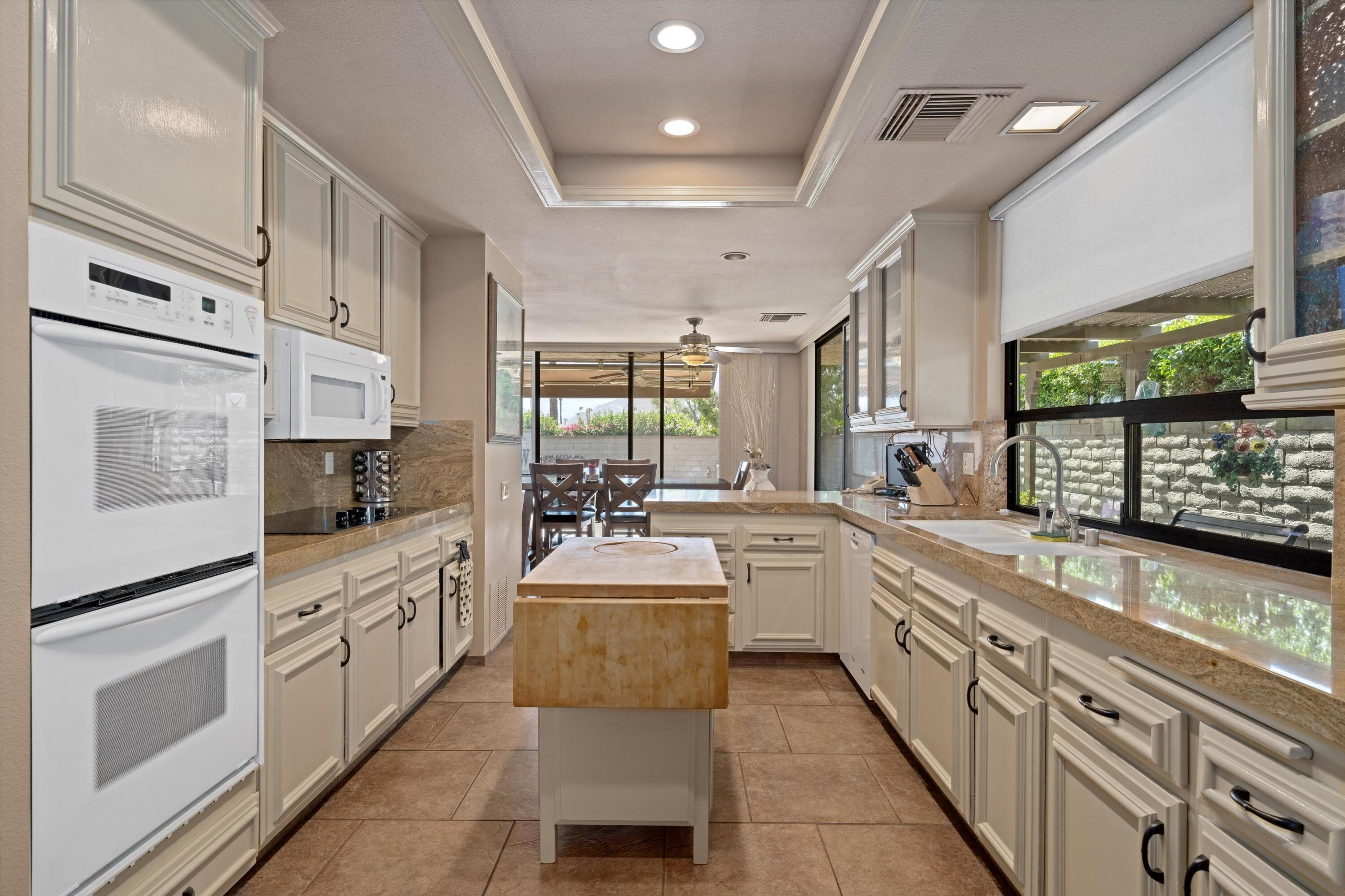 48 Cornell Drive Rancho Mirage, CA 92270 - Photo 14 of 39 a large kitchen with stainless steel appliances lots of counter space and windows