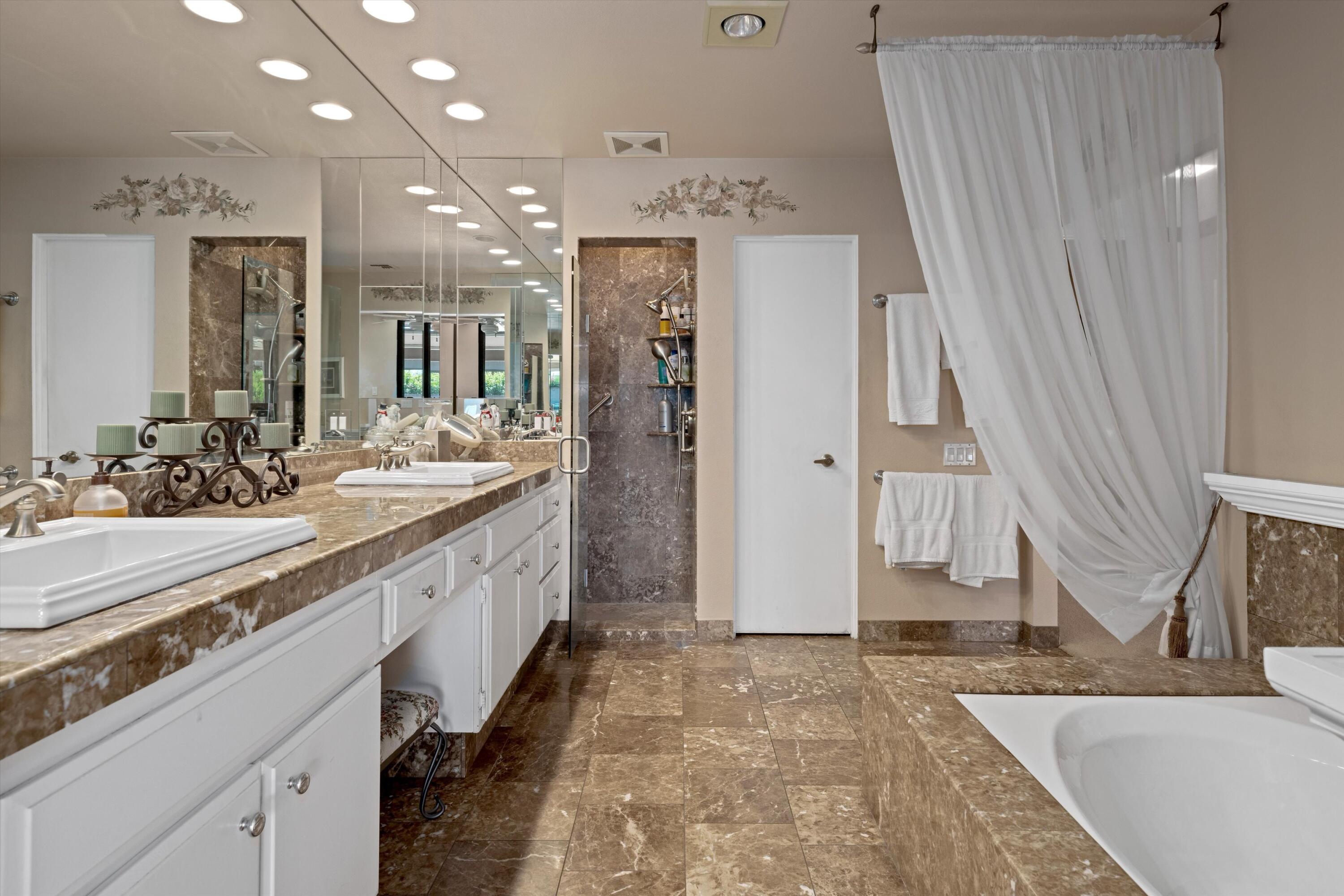 48 Cornell Drive Rancho Mirage, CA 92270 - Photo 22 of 39 a large bathroom with a granite countertop sink a toilet a mirror and shower