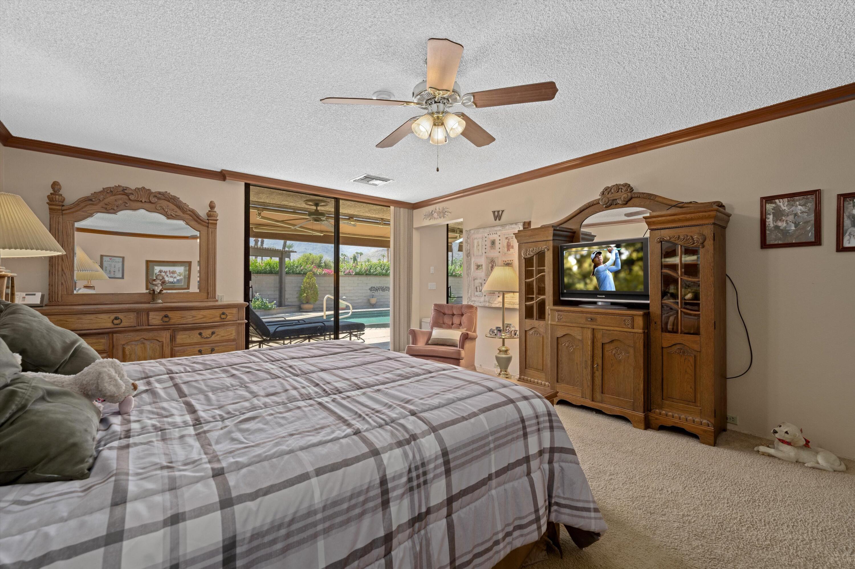 48 Cornell Drive Rancho Mirage, CA 92270 - Photo 24 of 39 a bedroom with a bed and a chandelier