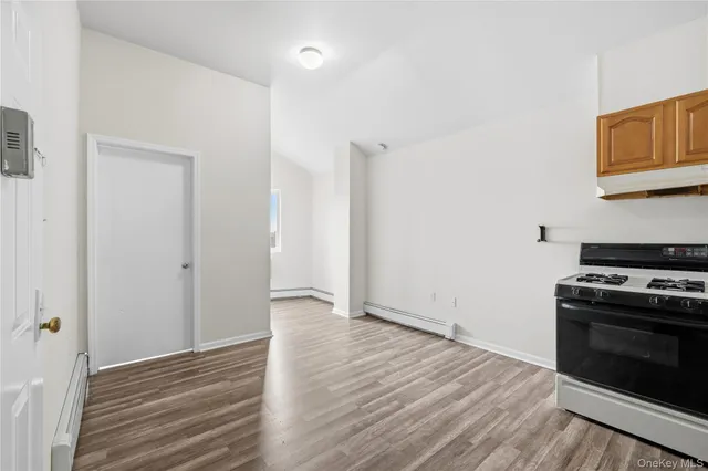 a view of a kitchen with wooden floor and a stove top oven