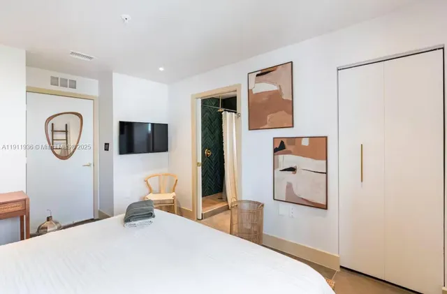 a bedroom with a bed and a refrigerator