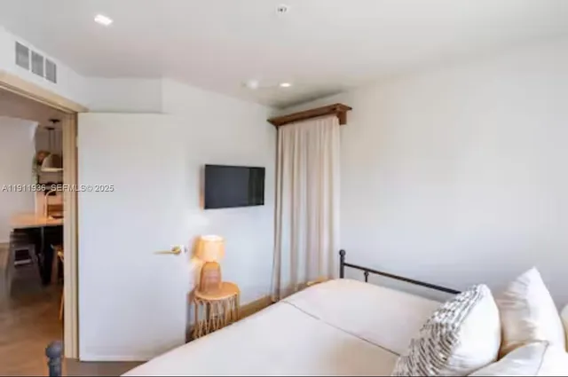a bedroom with a bed and a television