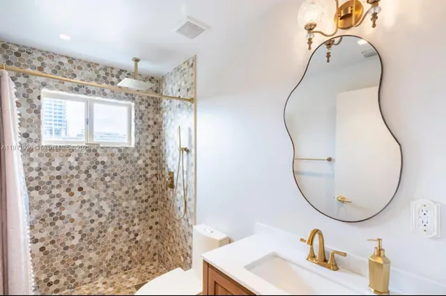 a bathroom with a sink a mirror and shower in it