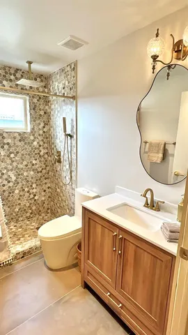 a bathroom with a granite countertop sink and a mirror