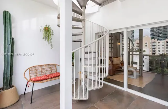 a room with stairs and a potted plant