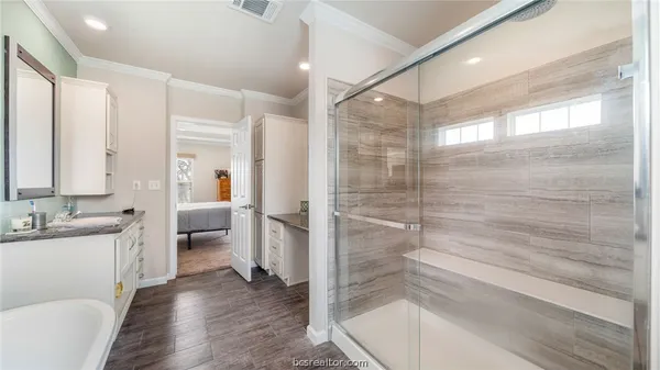 a bedroom with a bed and a flat screen tv on dresser