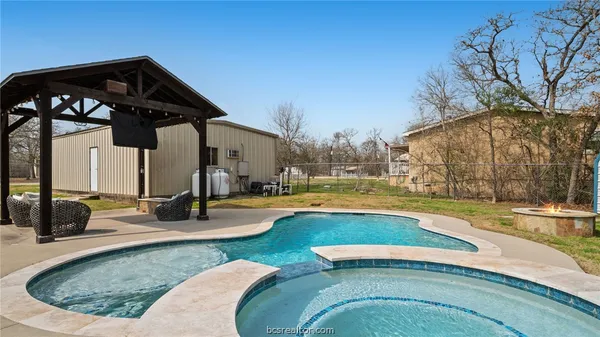 a view of a house with swimming pool and a yard