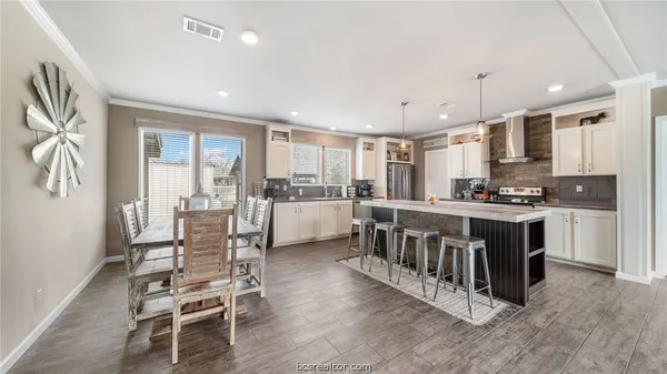 a large kitchen with stainless steel appliances granite countertop a lot of counter space and wooden floor