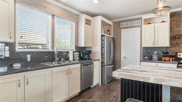 a kitchen with granite countertop white cabinets and stainless steel appliances