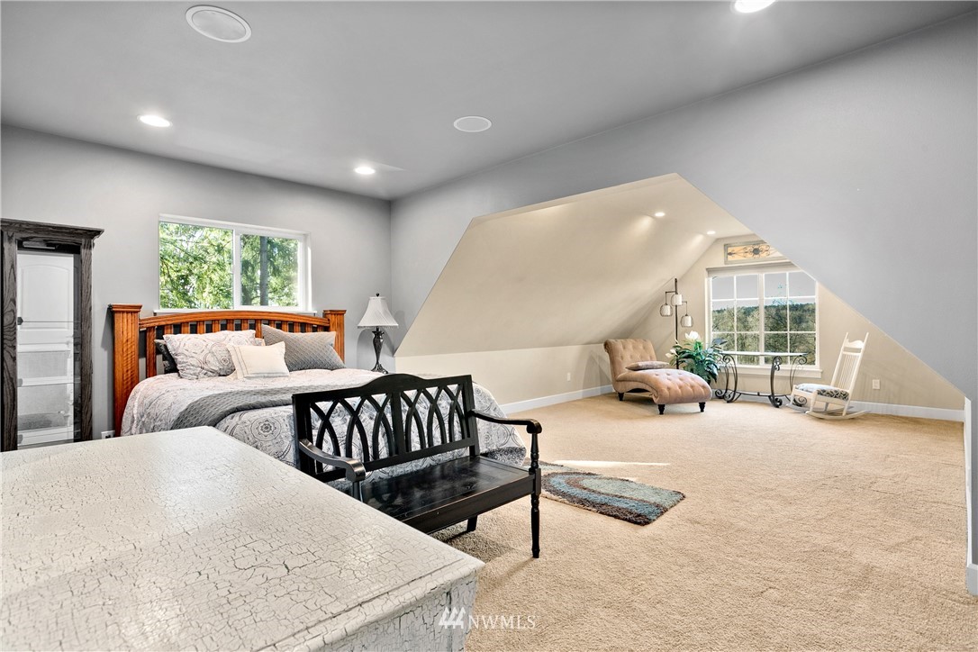 27515 Rose Road Arlington, WA 98223 - Photo 19 of 34 a spacious bedroom with a bed a couch and a large window