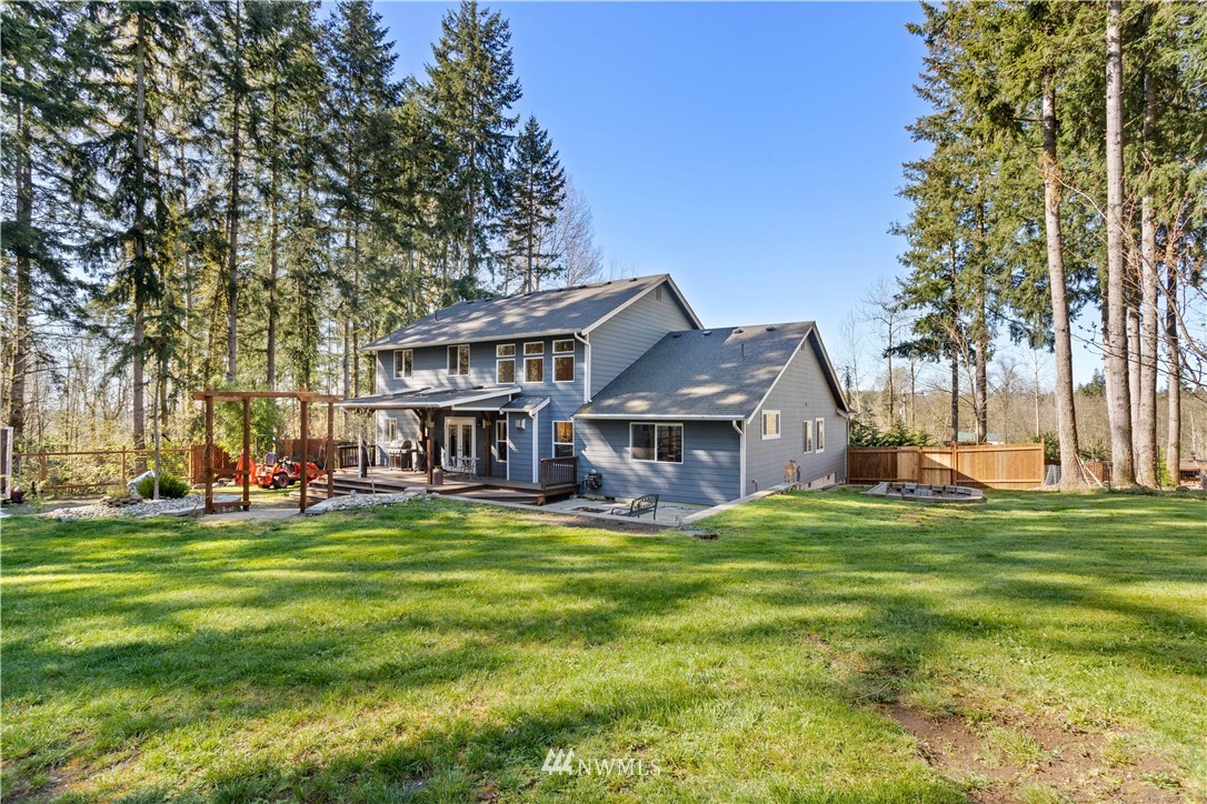 27515 Rose Road Arlington, WA 98223 - Photo 25 of 34 a view of a house with a big yard and large trees