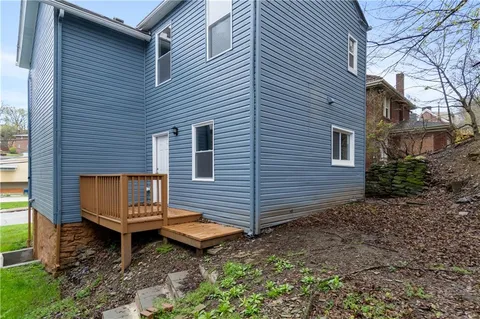 a wooden bench sitting in front of a house