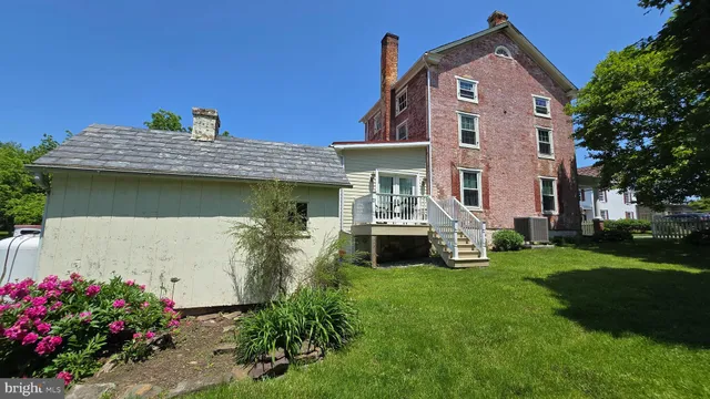 a view of a house with a small yard and wooden fence