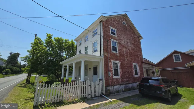 a view of a house with a yard and porch