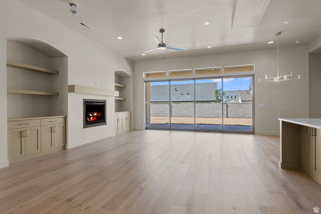 2955 East Rimrunner Drive St. George, UT 84790 - Photo 8 of 35 Open-concept living space featuring wood-finish flooring, a contemporary fireplace with mantel, built-in cabinetry, and a ceiling fan