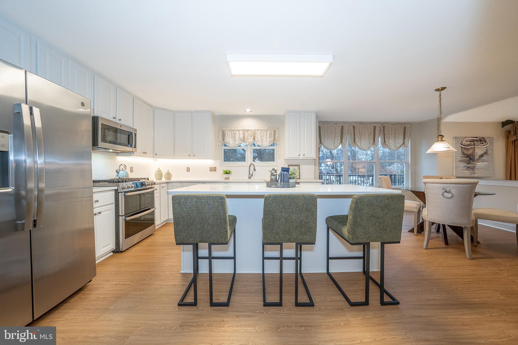 824 Waverly Road Kennett Square, PA 19348 - Photo 11 of 42 a kitchen with stainless steel appliances granite countertop a dining table chairs refrigerator and sink