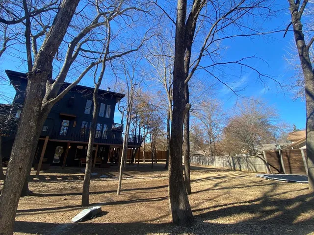 a view of a house with a tree next to a yard