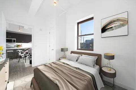 a bedroom with a bed and a view of kitchen