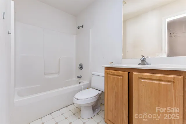 a bathroom with a granite countertop sink a toilet and bathtub