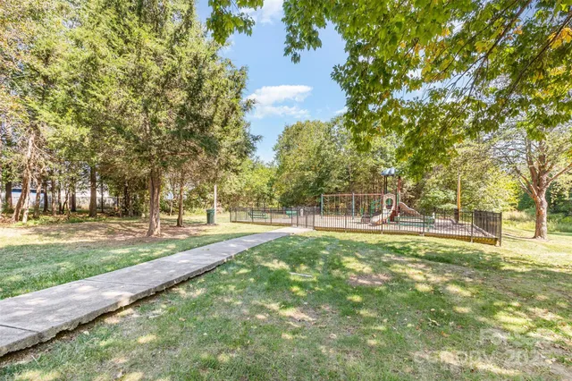 a view of yard with tree and wooden fence