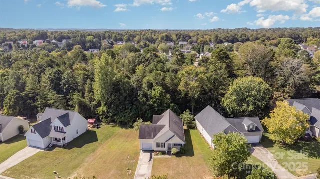 an aerial view of a house with a yard and lake view