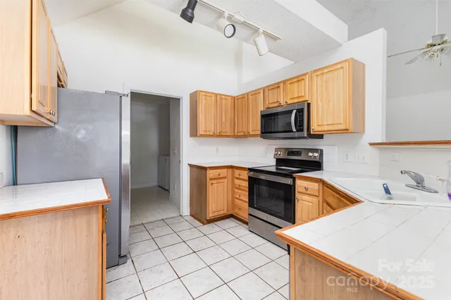 a kitchen with stainless steel appliances granite countertop a sink and a stove top oven with wooden floor