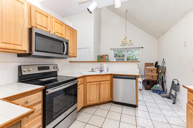 a kitchen with granite countertop a stove top oven microwave and cabinets