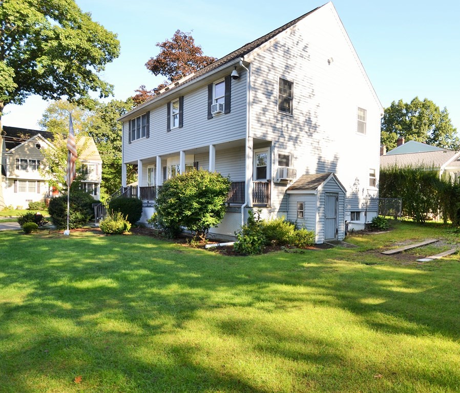 101 Wright Street Arlington, MA 02474 - Photo 4 of 18 a brick house with a big yard plants and big trees
