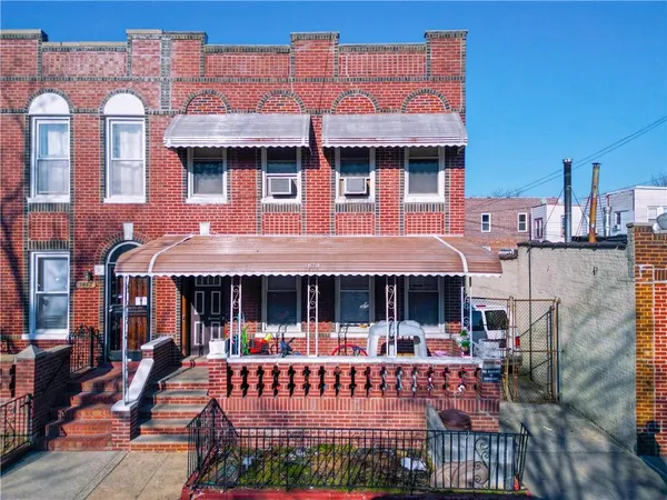 a view of a brick house with floor to ceiling windows and a table
