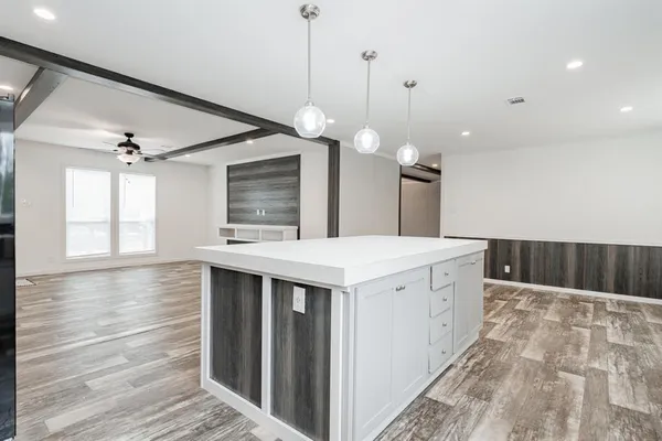 a kitchen with a stove a sink and a wooden floor