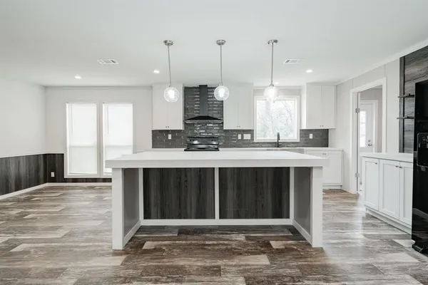 a kitchen with kitchen island granite countertop a stove a sink and a refrigerator
