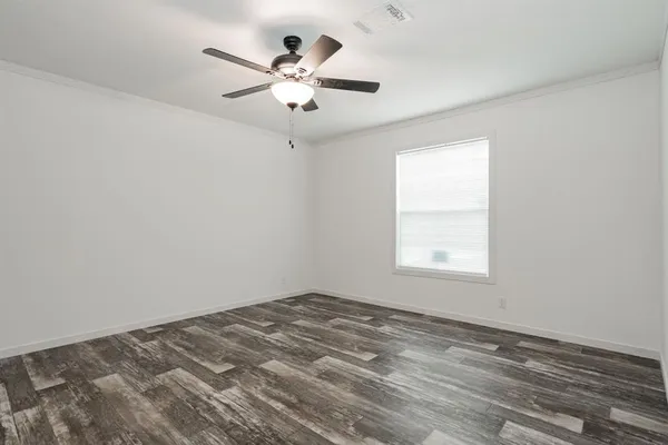 an empty room with a window and a fan