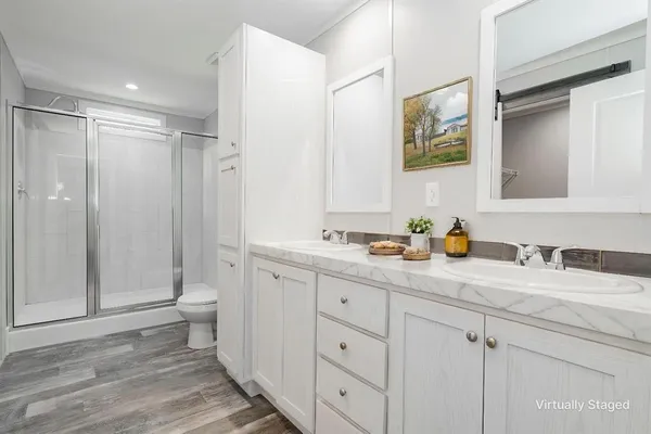 a bathroom with a granite countertop sink mirror vanity and toilet