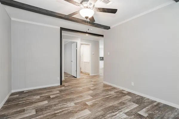 a view of a livingroom with wooden floor and a ceiling fan