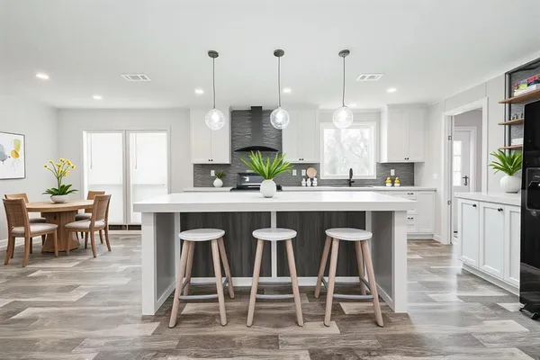 a kitchen with a dining table chairs and wooden floor