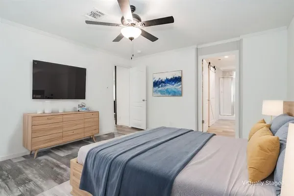 a bedroom with a bed tv and wooden floor