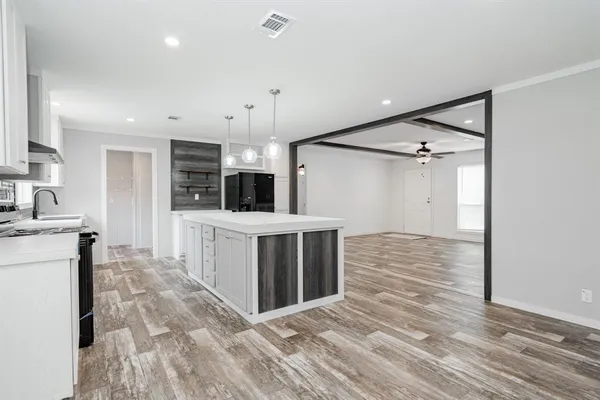 a large white kitchen with a stove top oven a sink and dishwasher