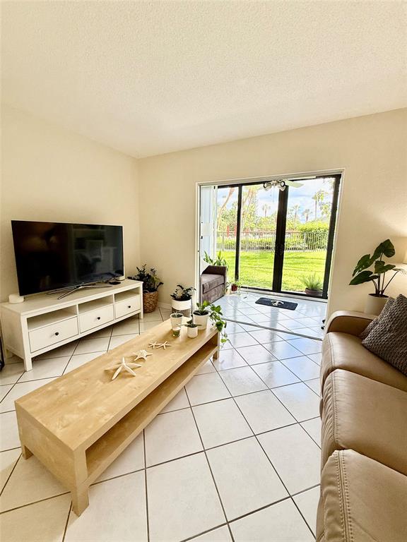 2350 Northeast 14th Street Causeway, Unit 108 Pompano Beach, FL 33062 - Photo 13 of 38 a living room with furniture and a flat screen tv