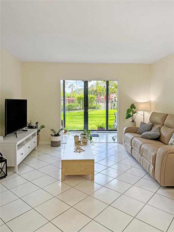 2350 Northeast 14th Street Causeway, Unit 108 Pompano Beach, FL 33062 - Photo 15 of 38 a living room with furniture and a flat screen tv