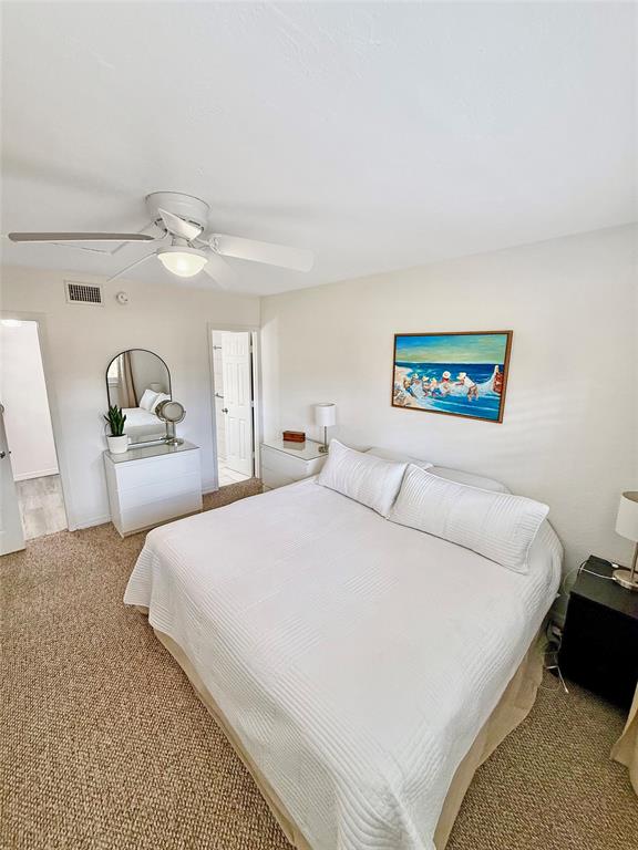 2350 Northeast 14th Street Causeway, Unit 108 Pompano Beach, FL 33062 - Photo 16 of 38 a bedroom with a bed and a chandelier