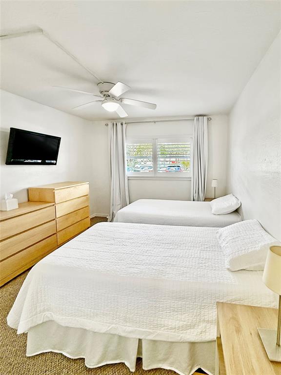 2350 Northeast 14th Street Causeway, Unit 108 Pompano Beach, FL 33062 - Photo 25 of 38 a bedroom with a bed and a flat screen tv