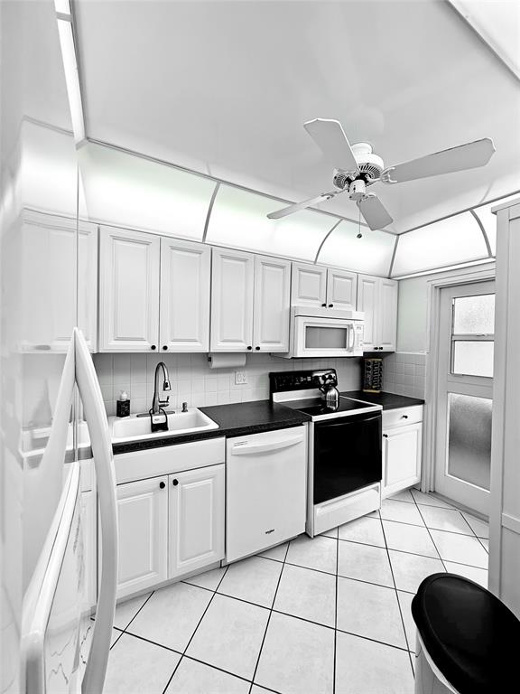 2350 Northeast 14th Street Causeway, Unit 108 Pompano Beach, FL 33062 - Photo 28 of 38 a kitchen with a sink appliances and cabinets