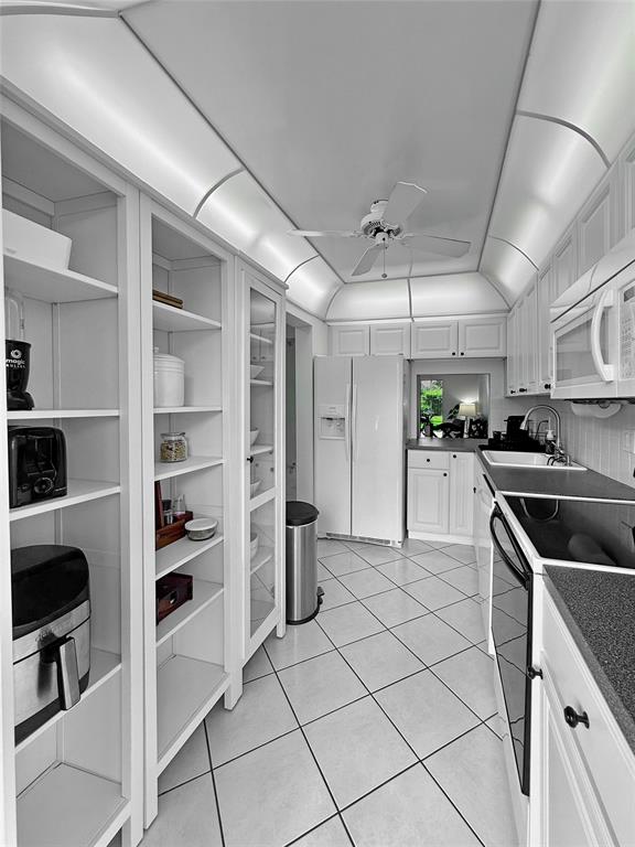 2350 Northeast 14th Street Causeway, Unit 108 Pompano Beach, FL 33062 - Photo 29 of 38 a kitchen with granite countertop a cabinets and steel stainless steel appliances