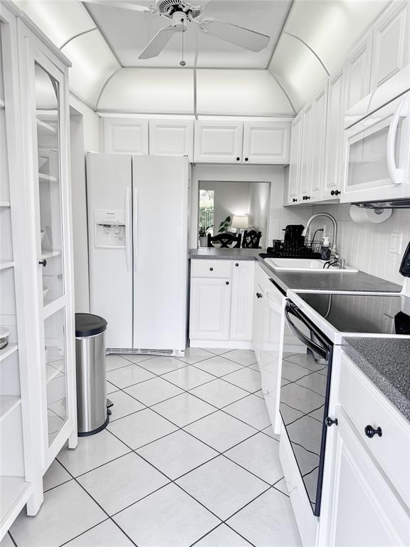 2350 Northeast 14th Street Causeway, Unit 108 Pompano Beach, FL 33062 - Photo 30 of 38 a kitchen with stainless steel appliances granite countertop a sink a stove a refrigerator and cabinets